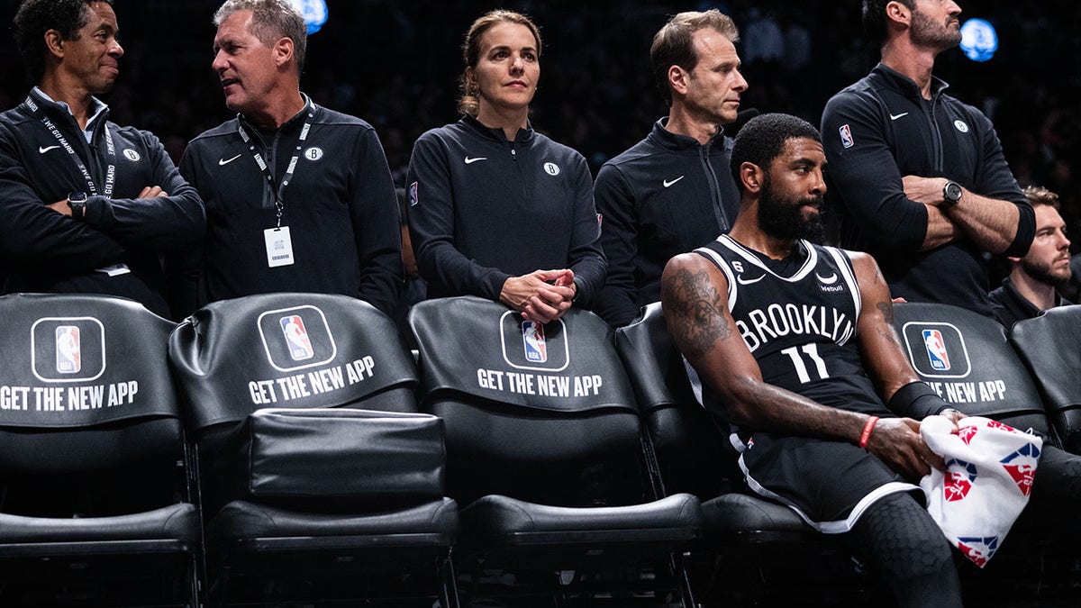 Kyrie Irving looks on from the Nets bench