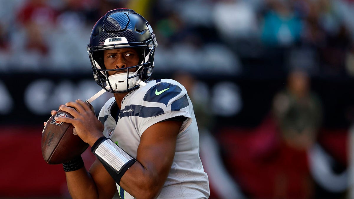 Geno Smith warms up before a game against the Cardinals