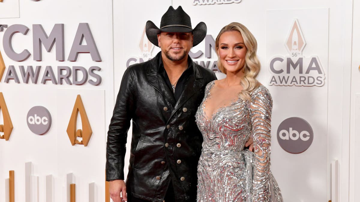 Jason Aldean and Brittany Aldean smile on the carpet of the CMA Awards