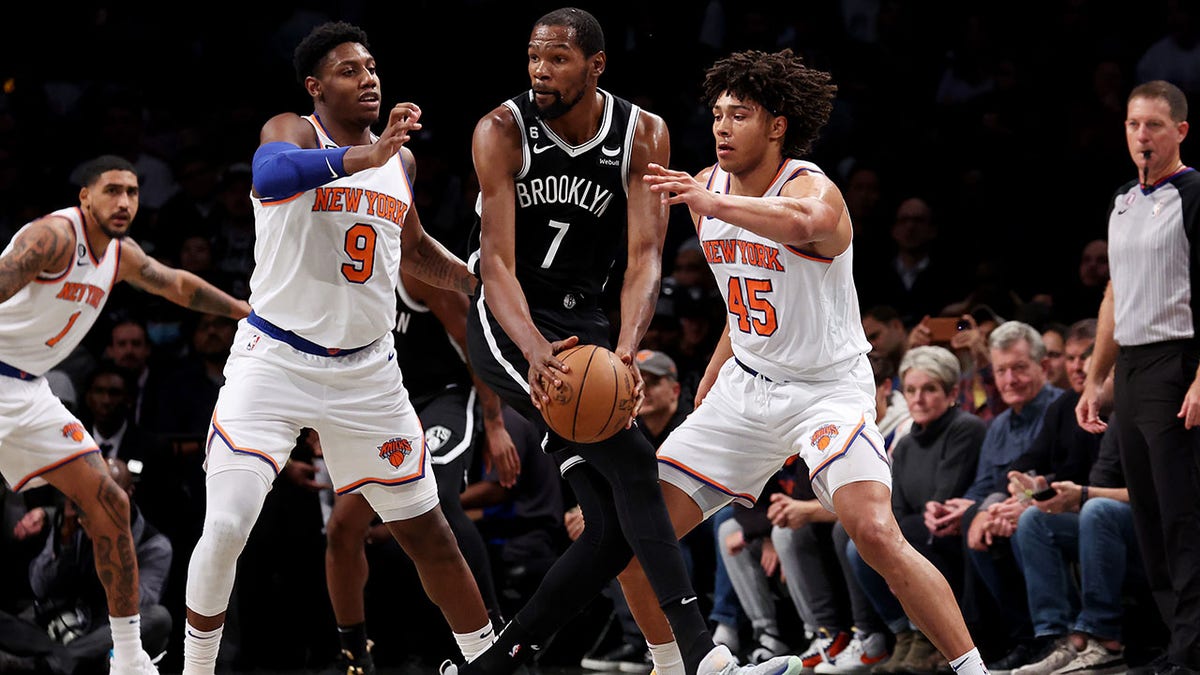 Kevin Durant is guarded by two Knicks players