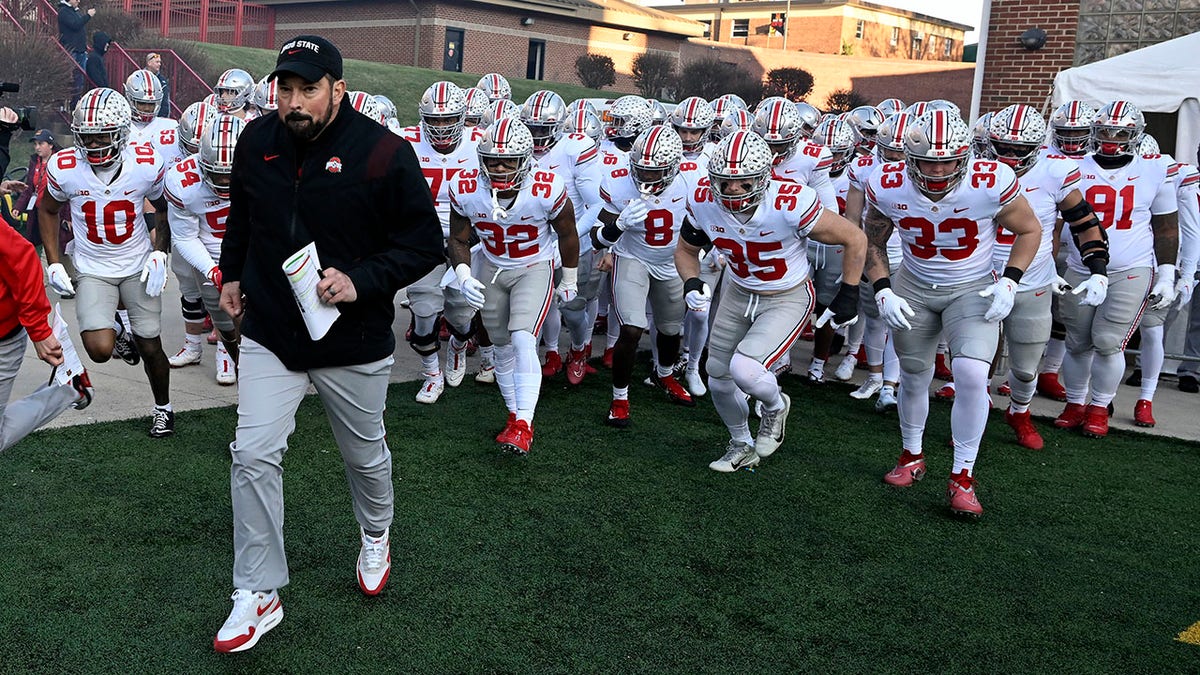 Head coach Ryan Day runs out with his Buckeyes