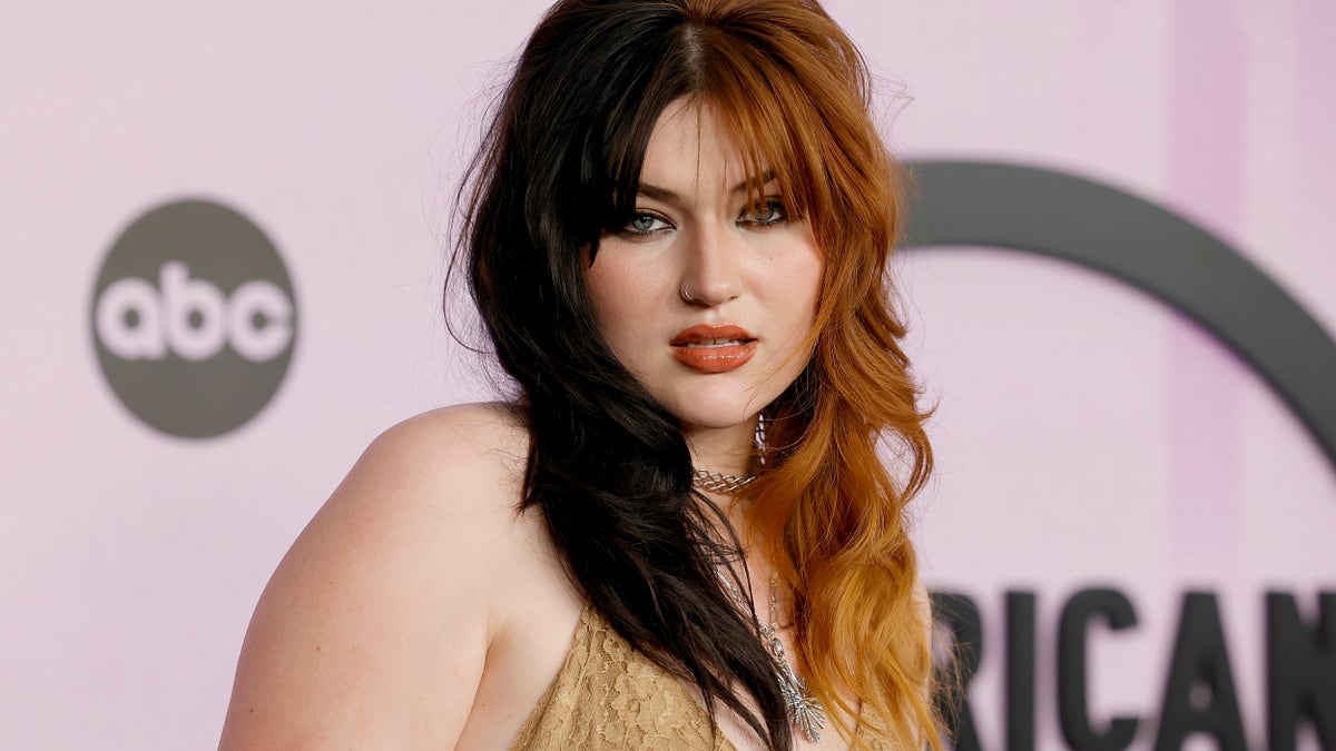 Gayle poses on the red carpet with half brown and half amber hair