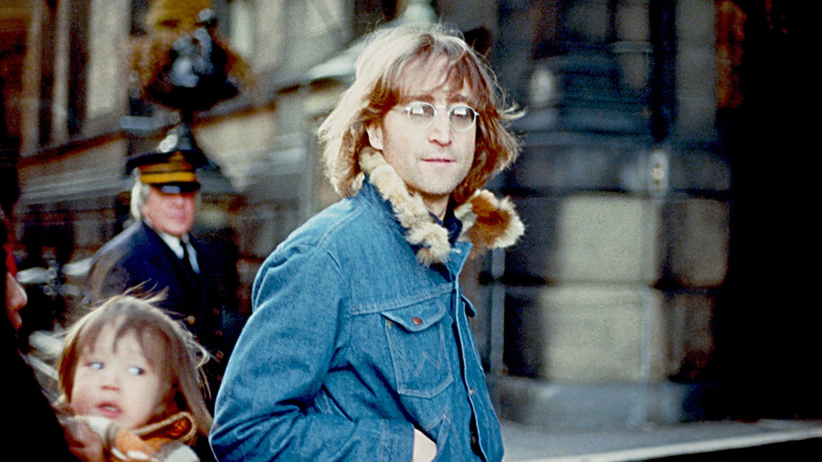 John Lennon posing for a photo outside his apartment in New York City