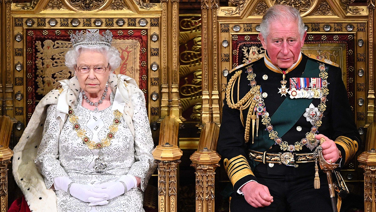 Queen Elizabeth sitting on the throne with King Charles