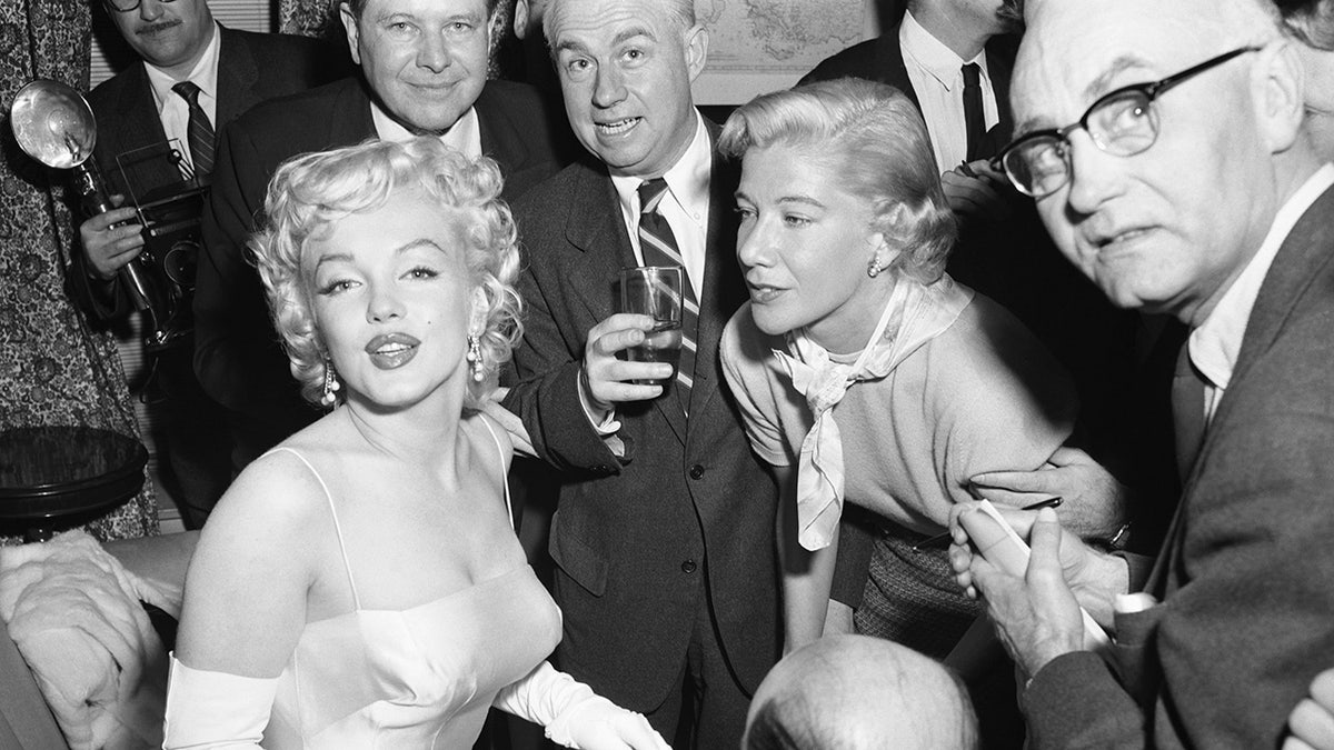 Marilyn Monroe surrounded by photographers