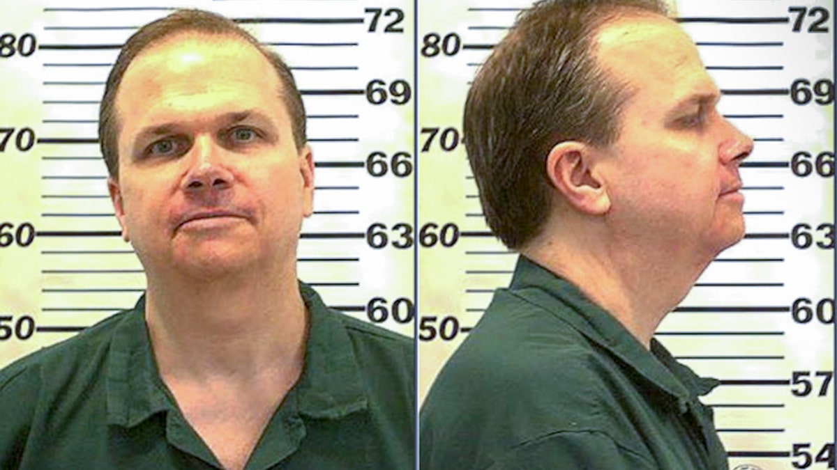 Mark David Chapman standing for his mugshot