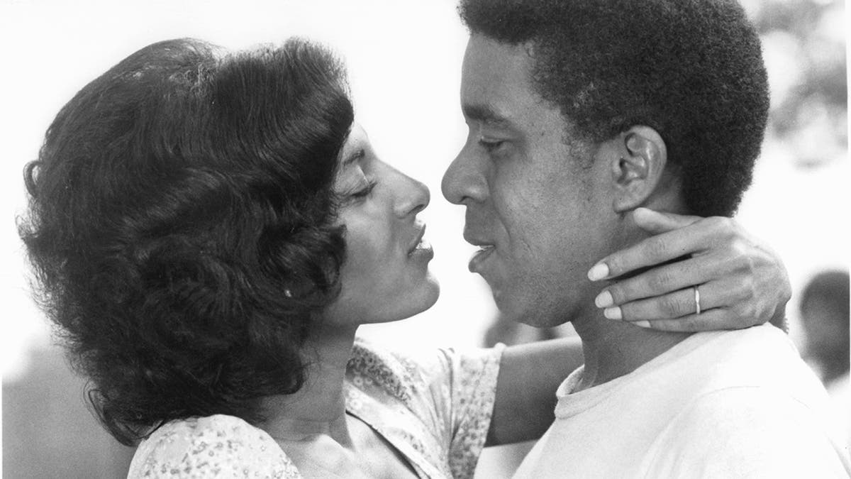 Pam Grier And Richard Pryor embrace to kiss in a scene from the film 'Greased Lightning'