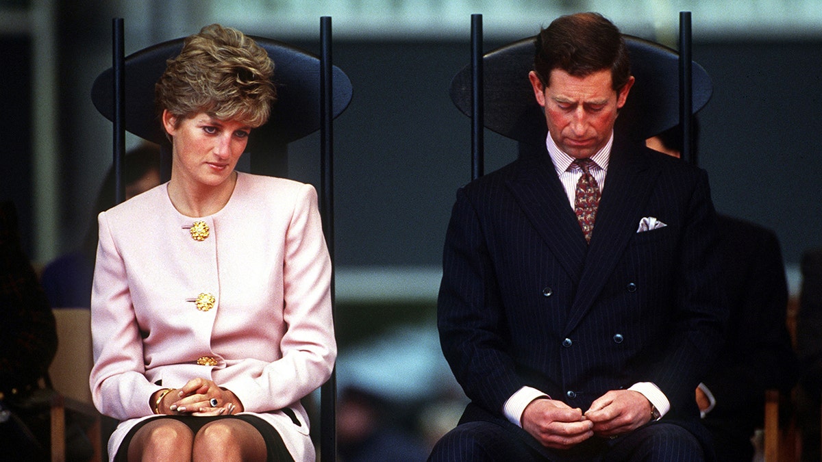 Princess Diana and Prince Charles looking somber at a public event