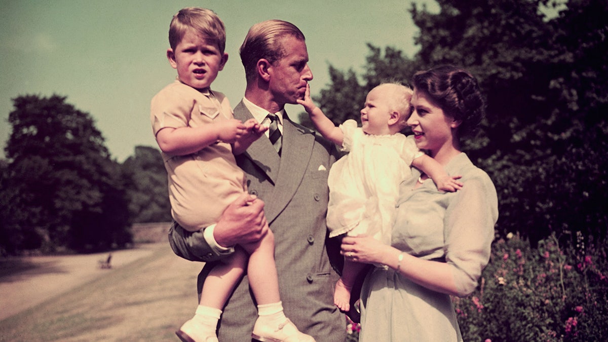 Queen Elizabeth and Prince Philip taking a stroll with two of their children