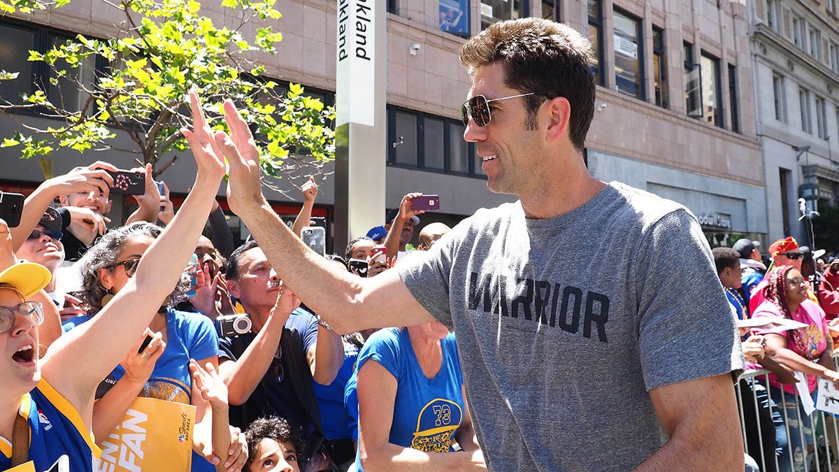 Bob Myers celebrates with fans during parade