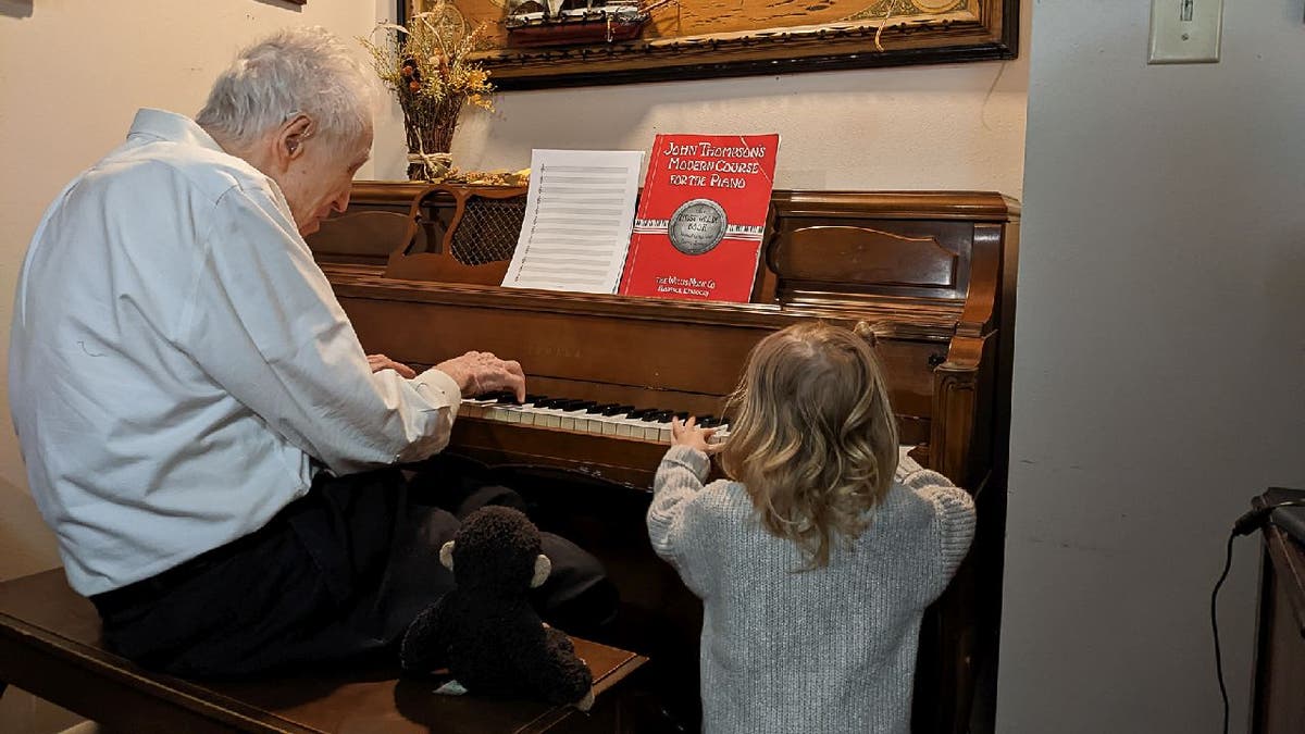 Harold Chilton plays the piano for his great-great granddaughter