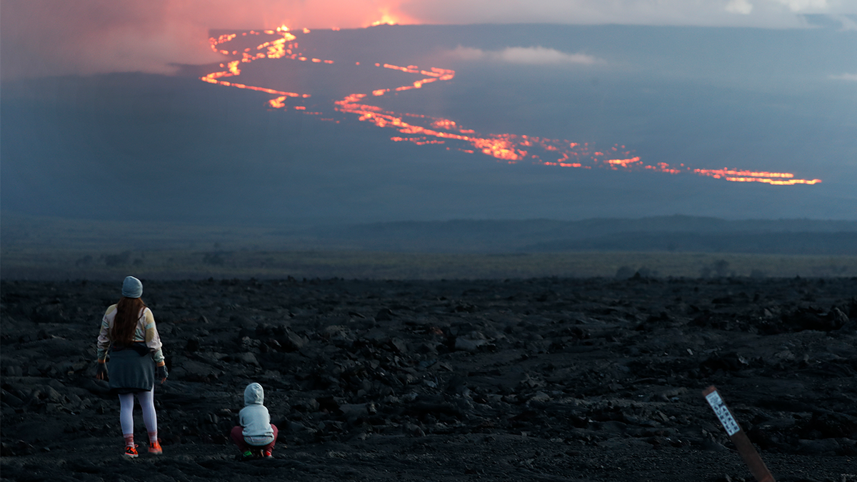 Spectators watch the lava flow