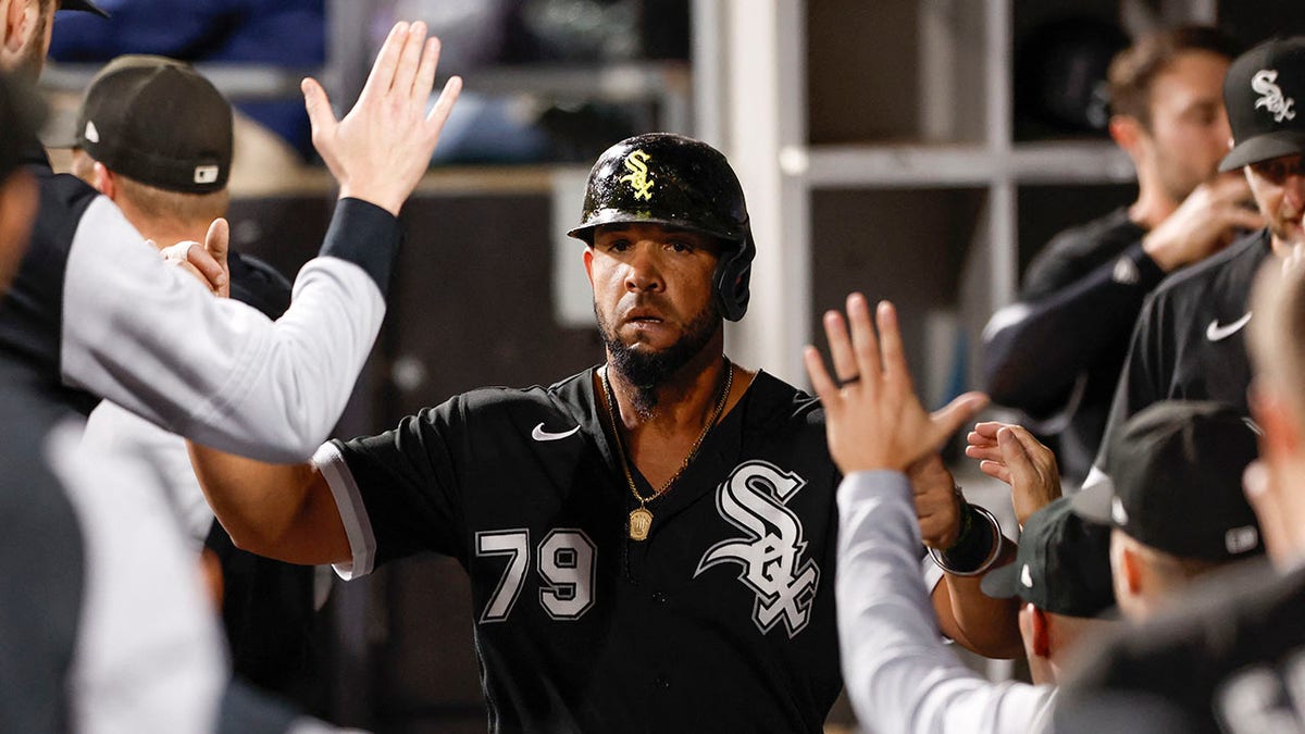 Jose Abreu slaps hands in the dugout