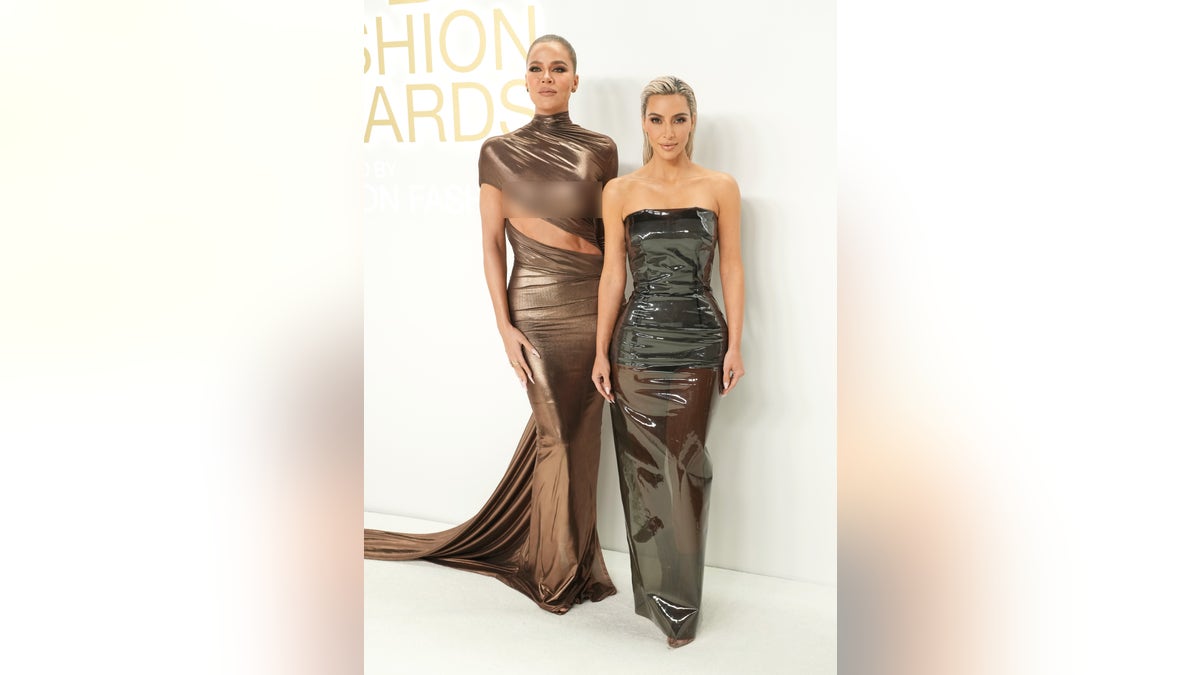 Sisters Khloe Kardashian and Kim Kardashian pose in fashionable dresses for awards show in New York