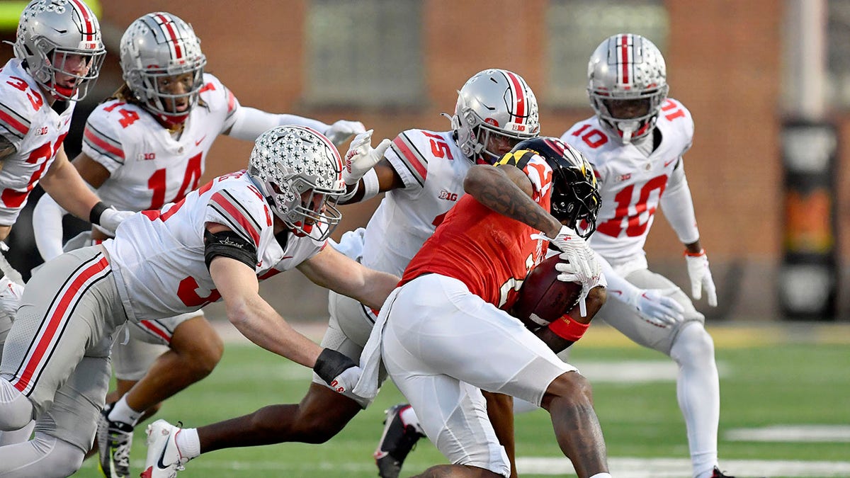 Ohio State football players attempt to make a tackle