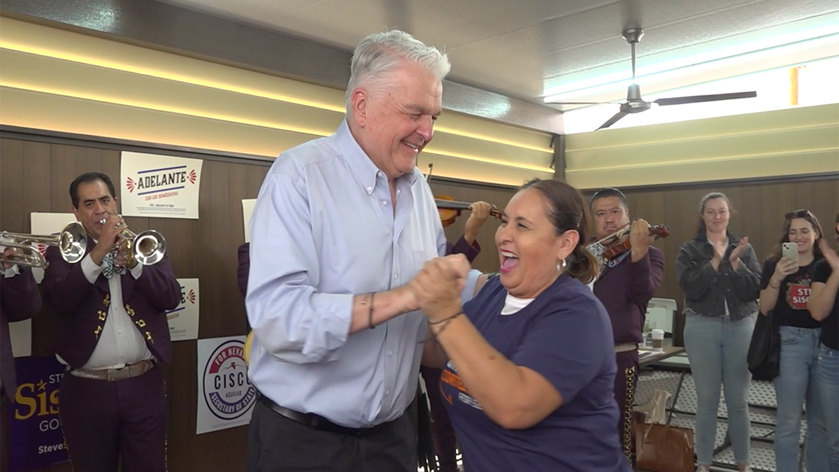 Governor Steve Sisolak dances with voter