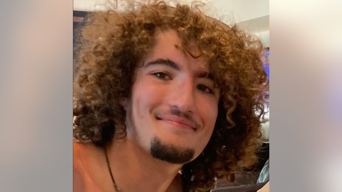Kellen Bischoff smiling and sporting a mop of unruly, curly hair.