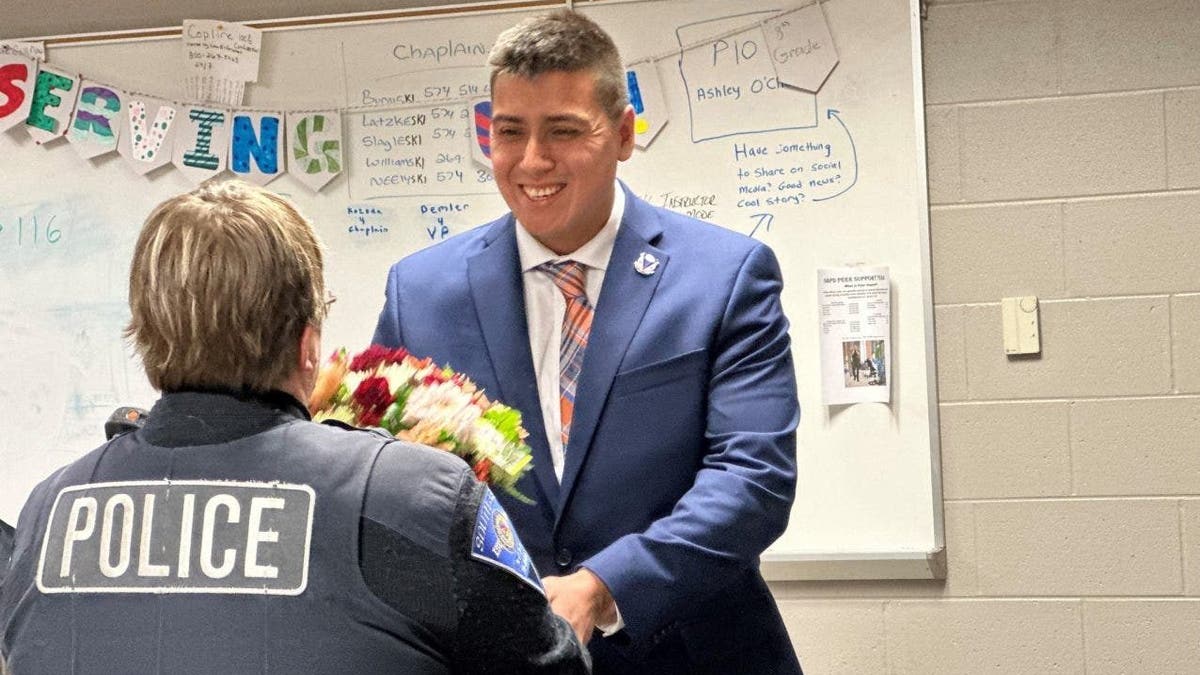 Roberto Theiss hands flowers to officer Anne Hayes