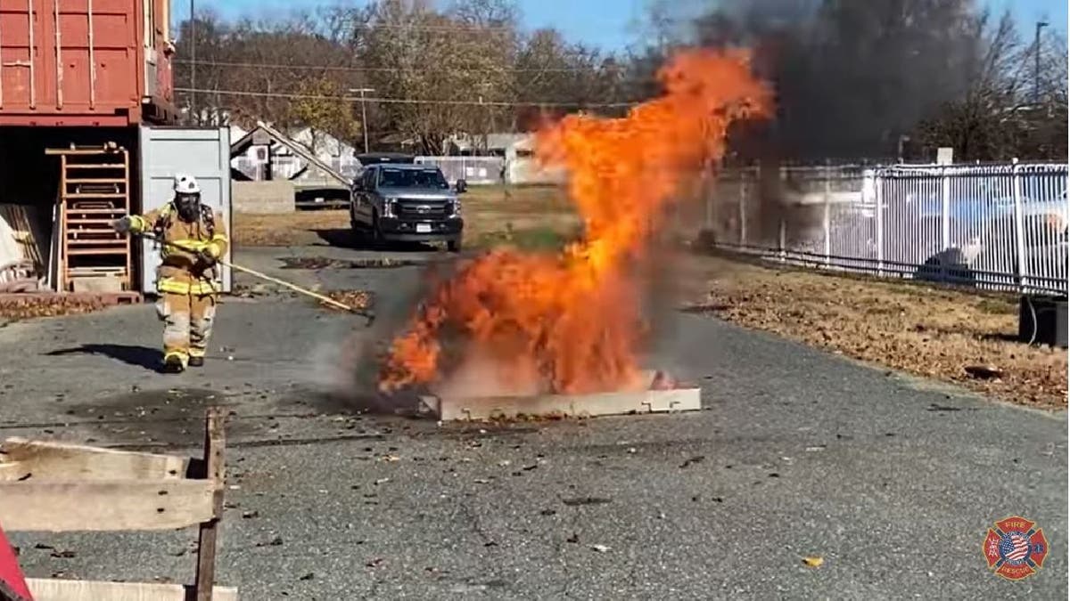 Stafford County Fire & Rescue firefighter dips frozen turkey into fryer