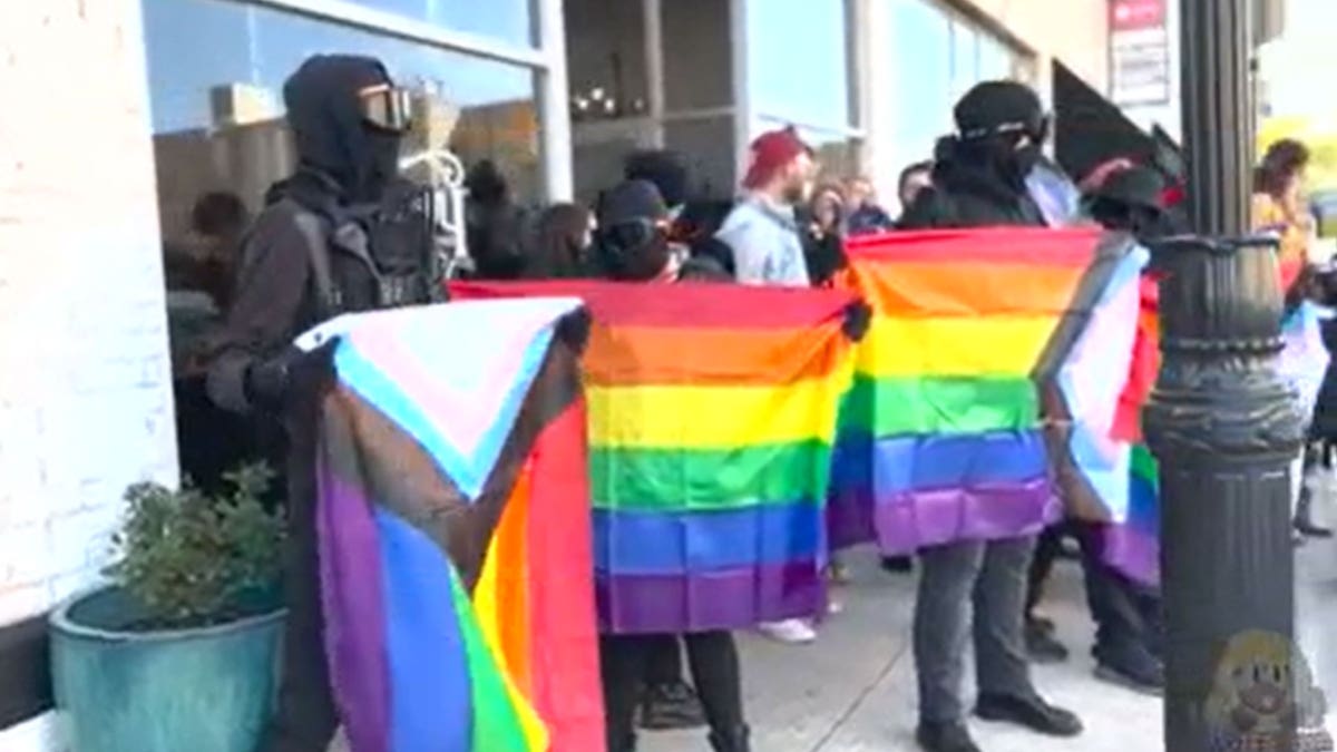 Exterior view of the bookstore with Antifa standing outside carrying lgbtq+ flags