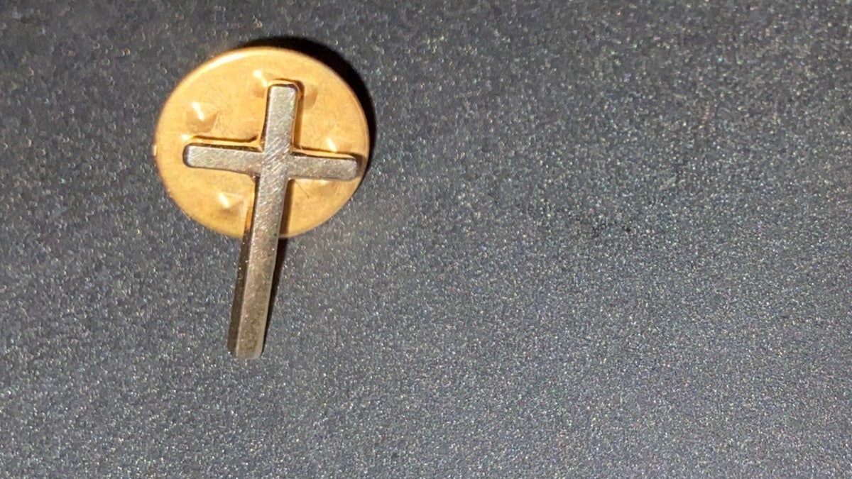 Derek Timms' cross lapel pin