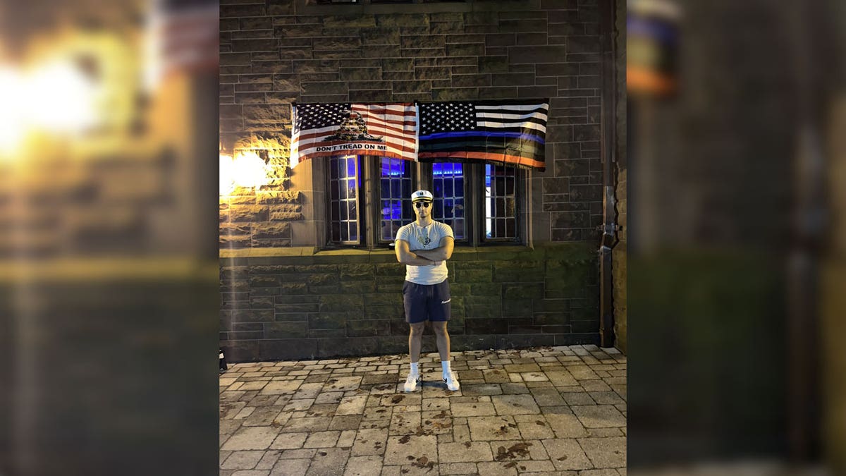 Student standing in front of flags