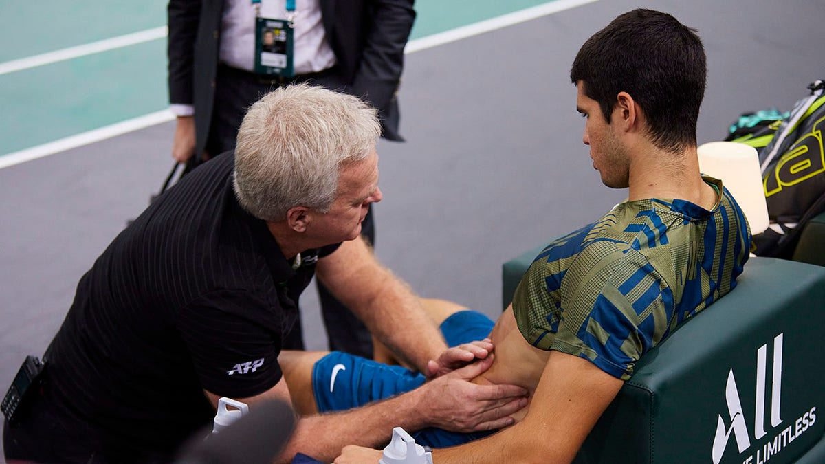 Carlos Alcaraz getting looked at by doctor