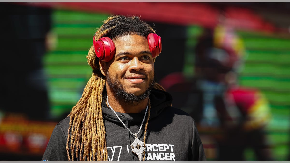 Chase Young smiles with headphones on