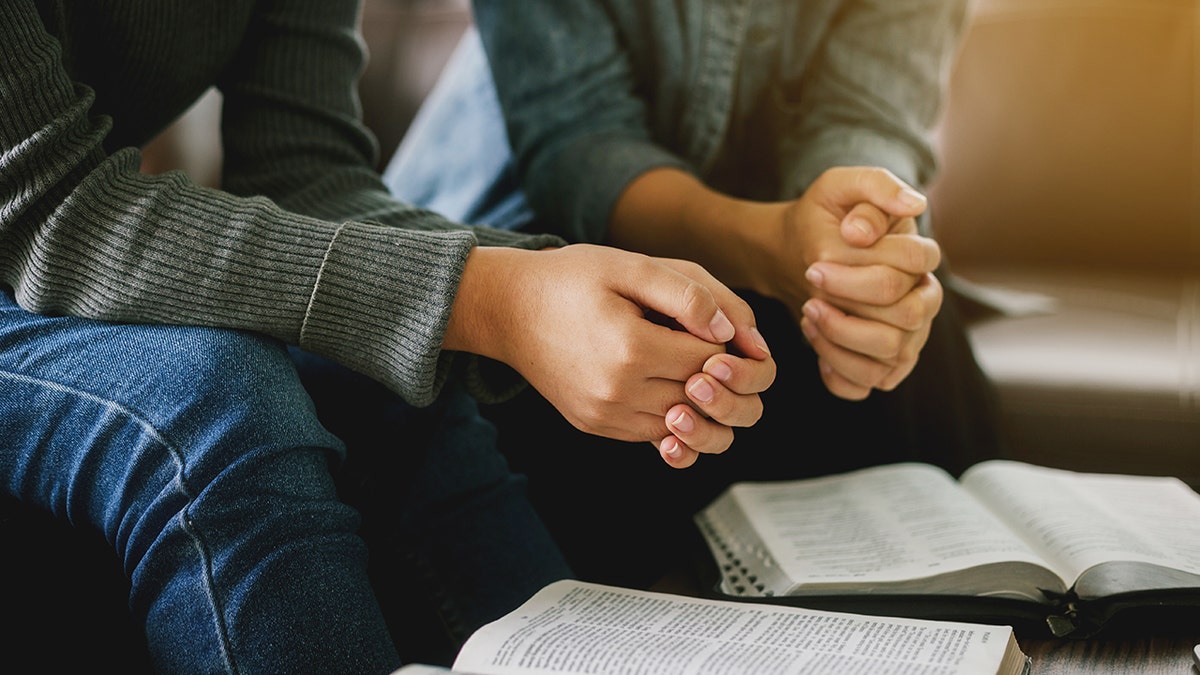 two women praying and reading bible