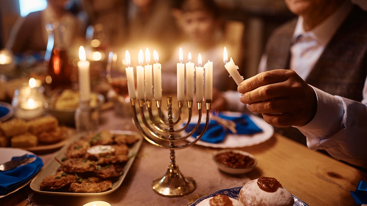 Family lighting Menorah and Hanukkah celebration