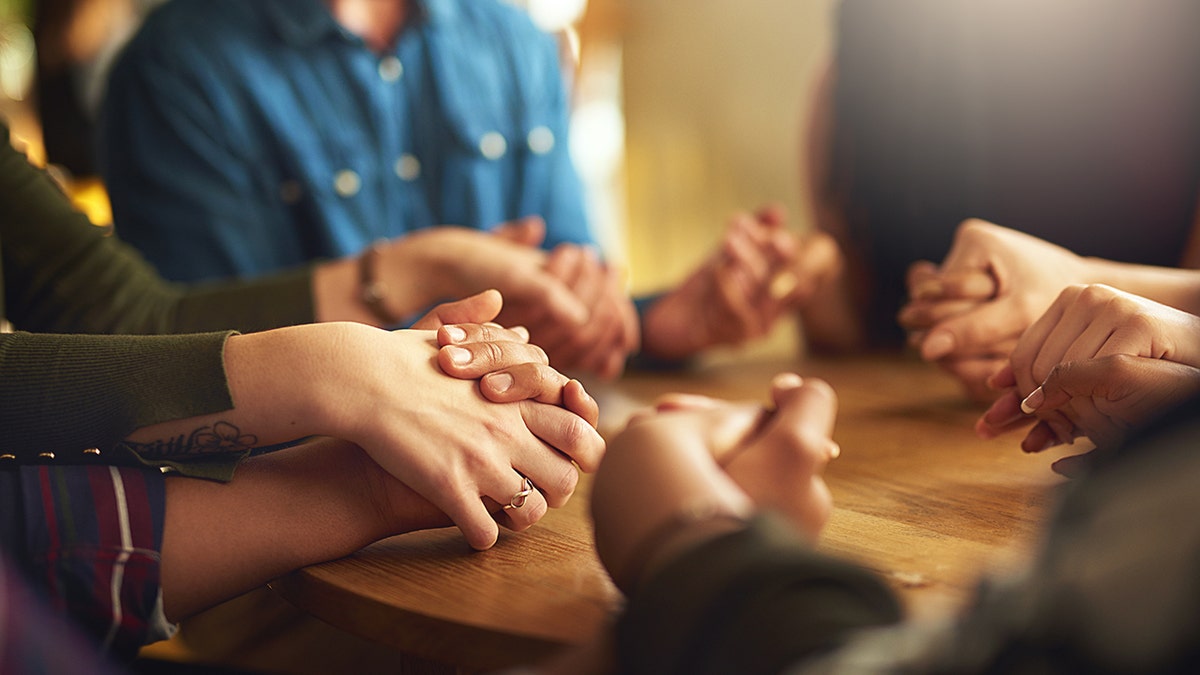 family praying around the table