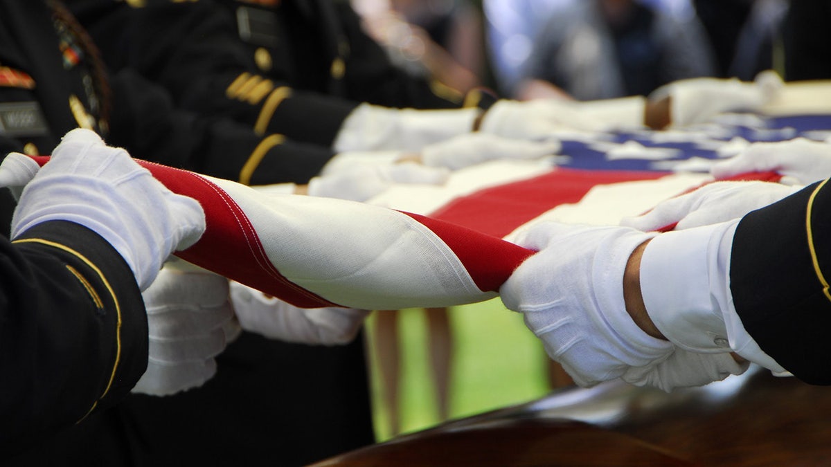 Soldiers fold American flag