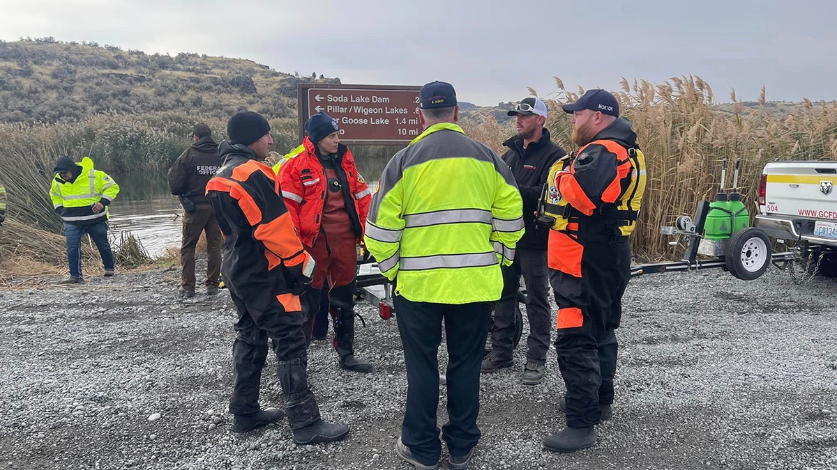 rescue officials talking near lake