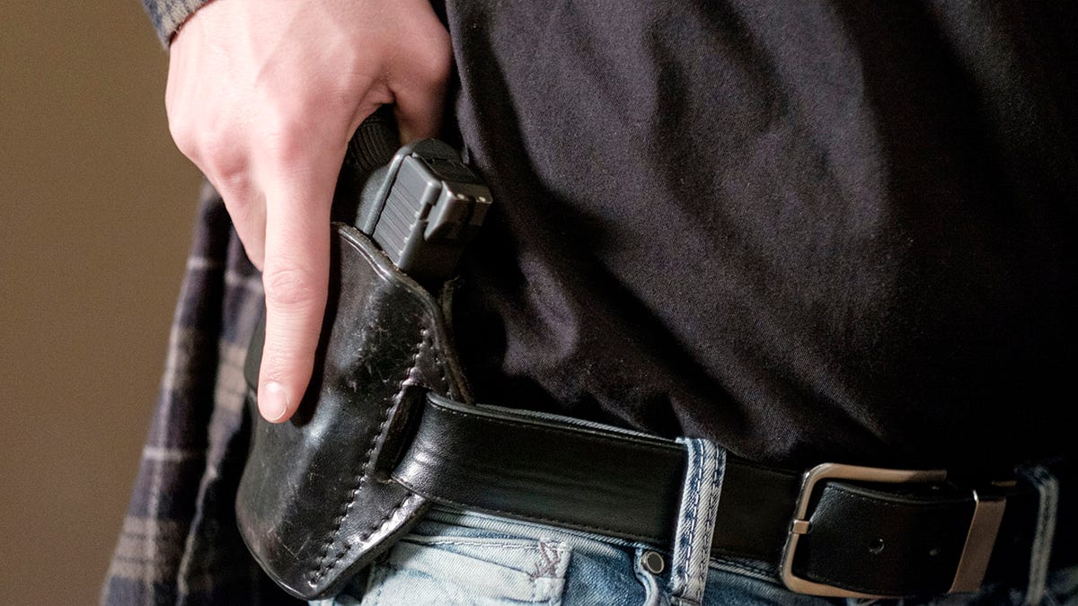 A man with a handgun in his holster