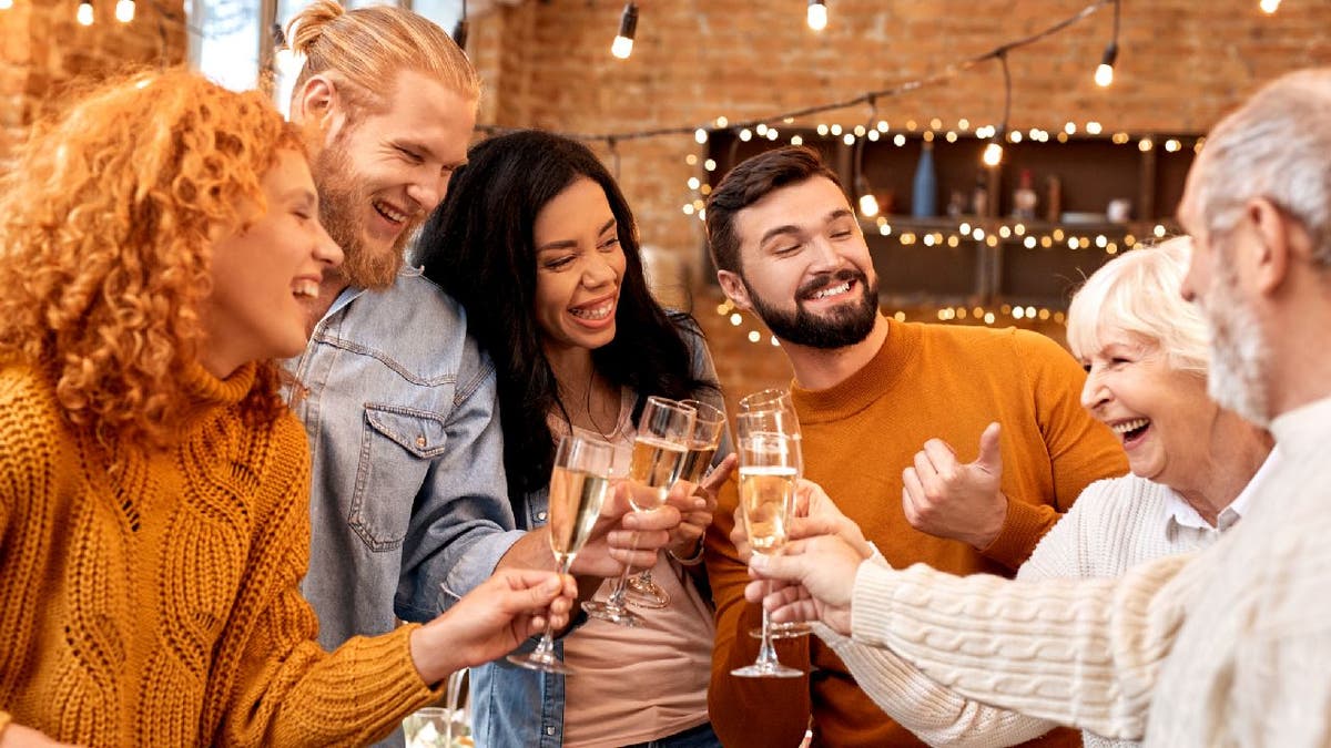Group of people toast champagne at holiday gathering