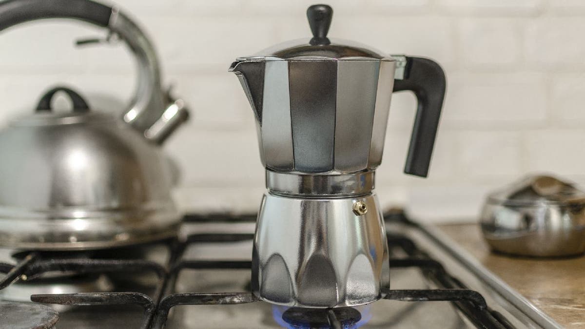 Moka pot on gas stove range with flame lit