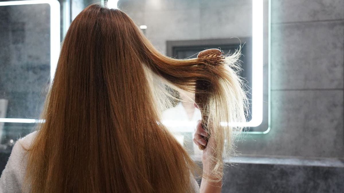 Woman brushes straight hair