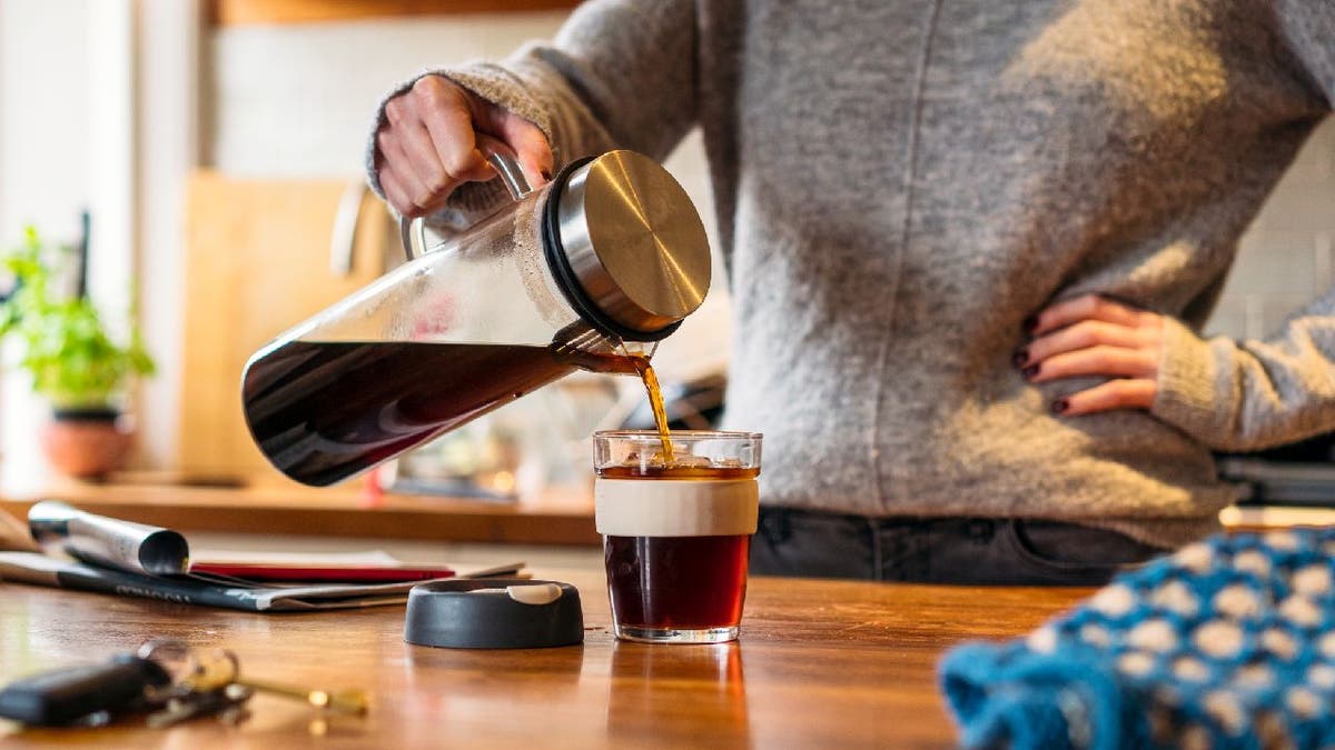 Woman pours cold brew into mug