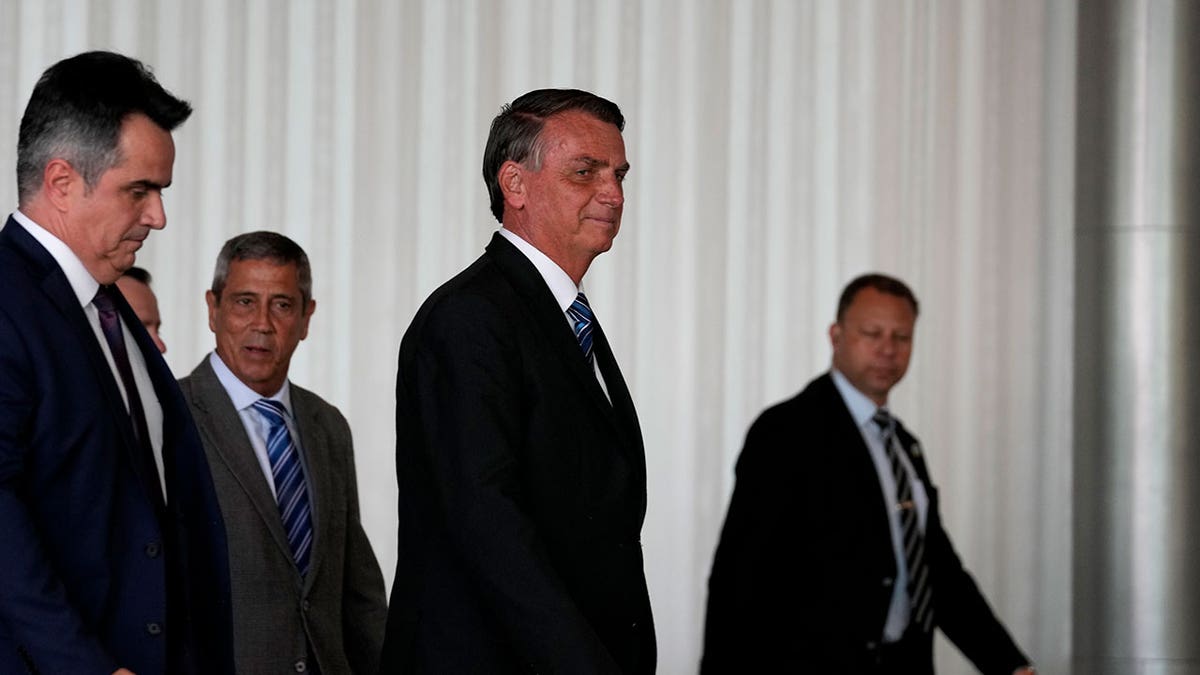 Jair Bolsonaro walking through a building with white interiors