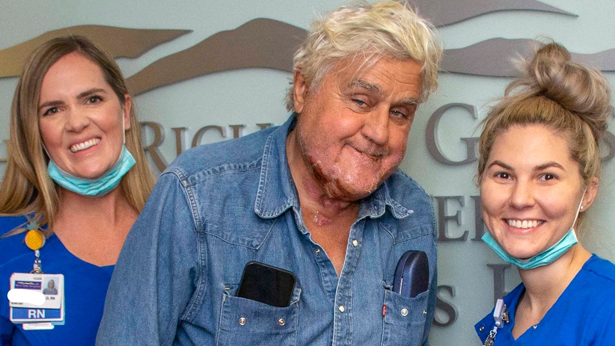 Jay Leno smiles with nurses while leaving the Grossman Burn Center.