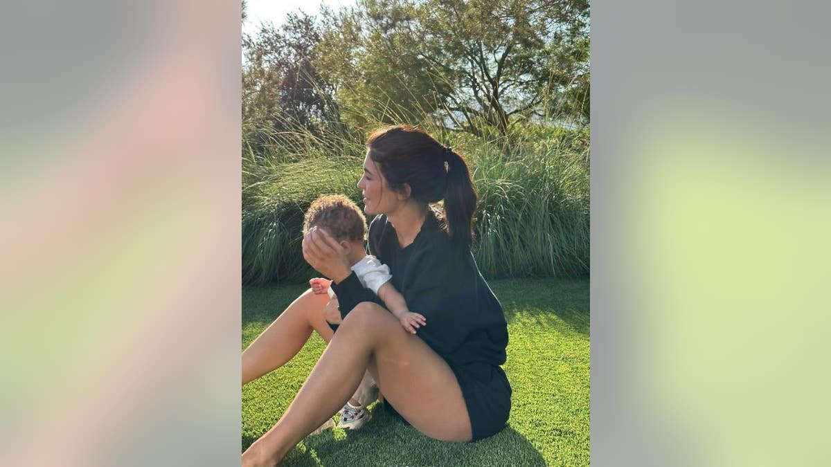 Kylie Jenner cradles her son on the grass