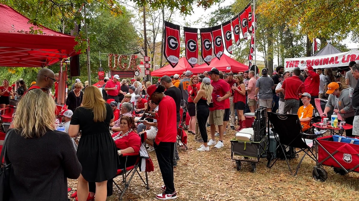 Crowds of people hang out at the Libation Station tailgate at the University of Georgia
