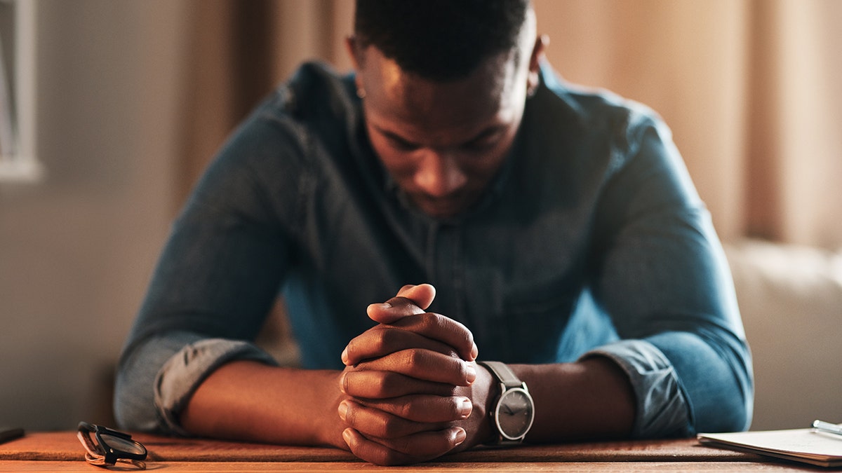 Man praying at his desk