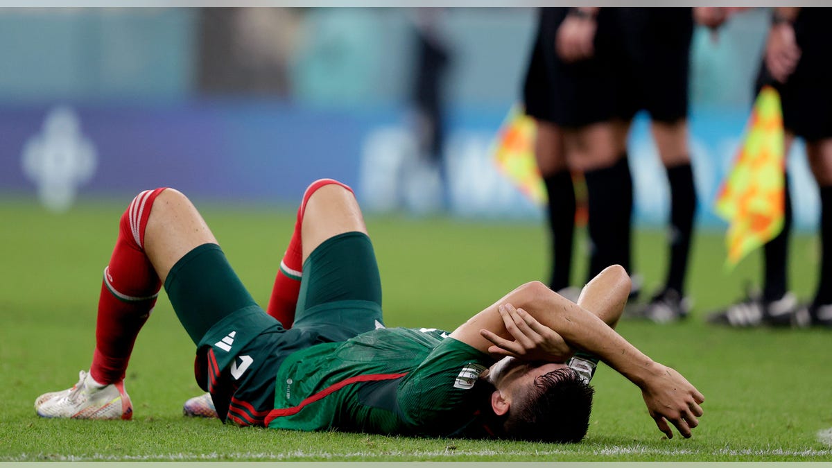 Cesar Montes lays on field with hands over head