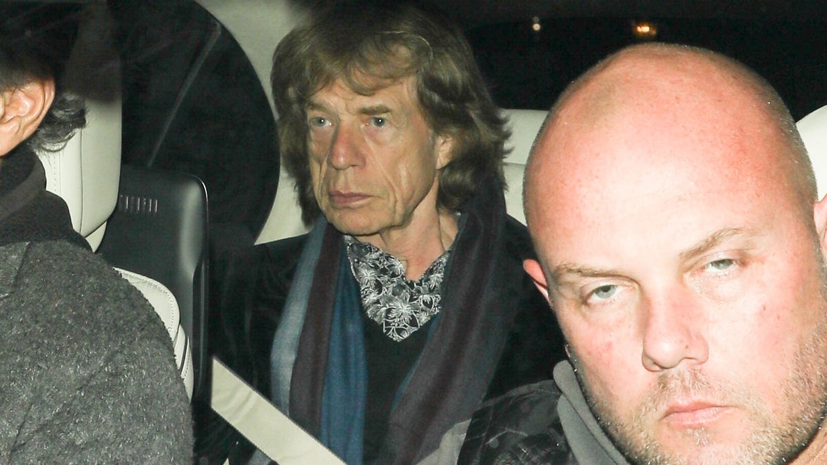 Mick Jagger sits in the backseat as he is driven to Leo DiCaprio's birthday party