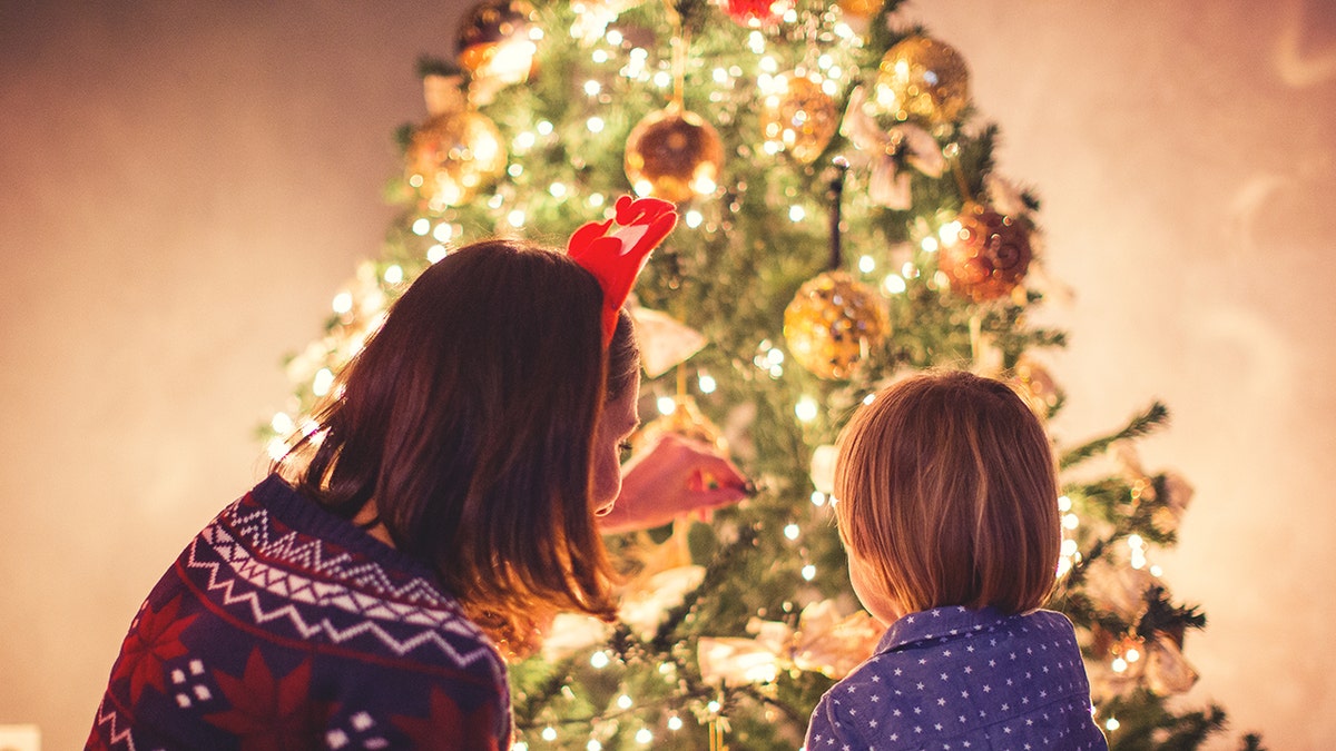 little boy and mother decorating Christmas tree