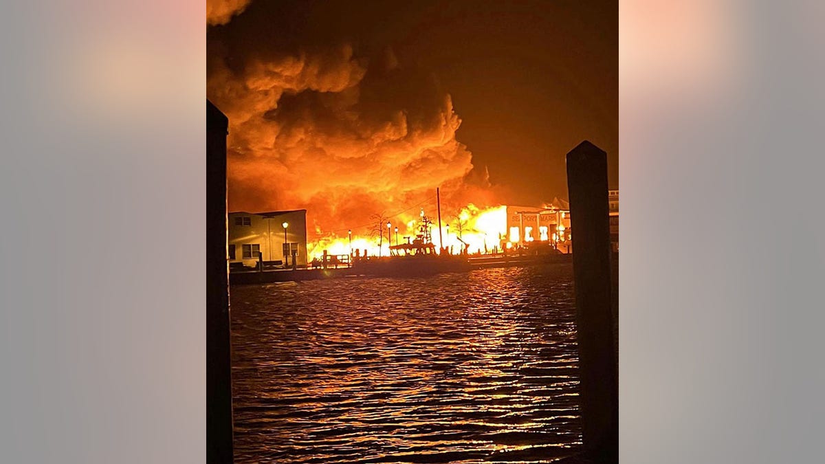 fire seen across water at old mystic seaport