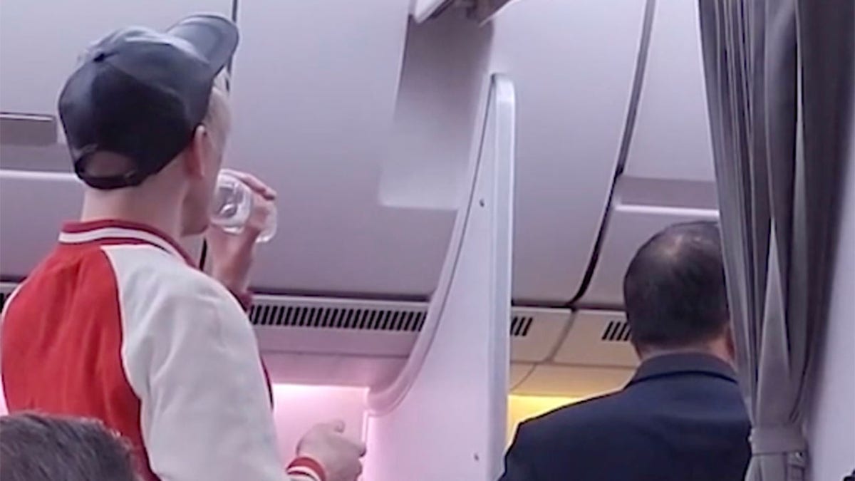 Passenger drinks from water bottle on flight