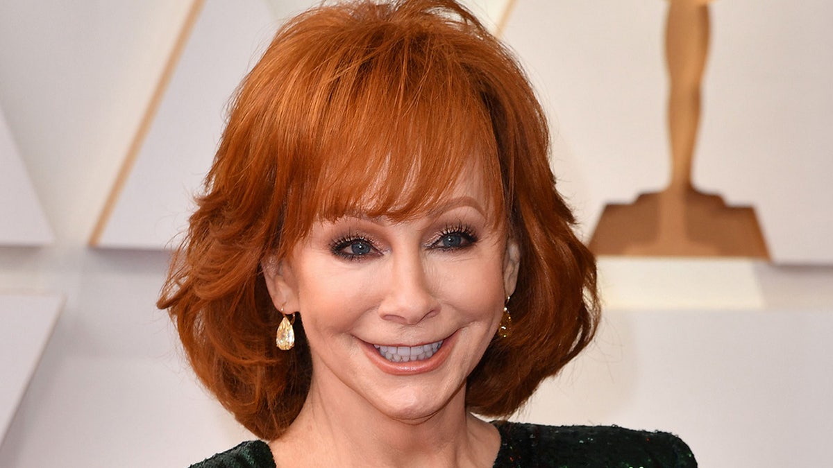 Reba McEntire smiles while on the red carpet at the Academy Awards in March