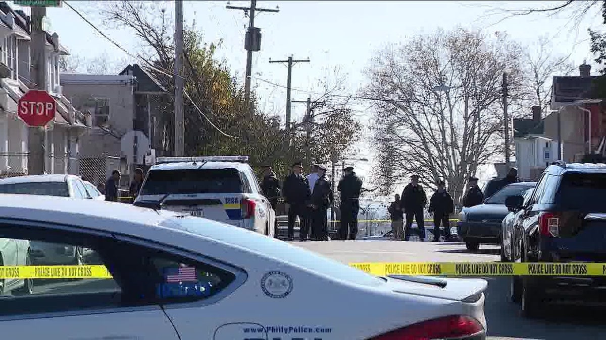 Police at crime scene in background, police cruiser, police tape foreground